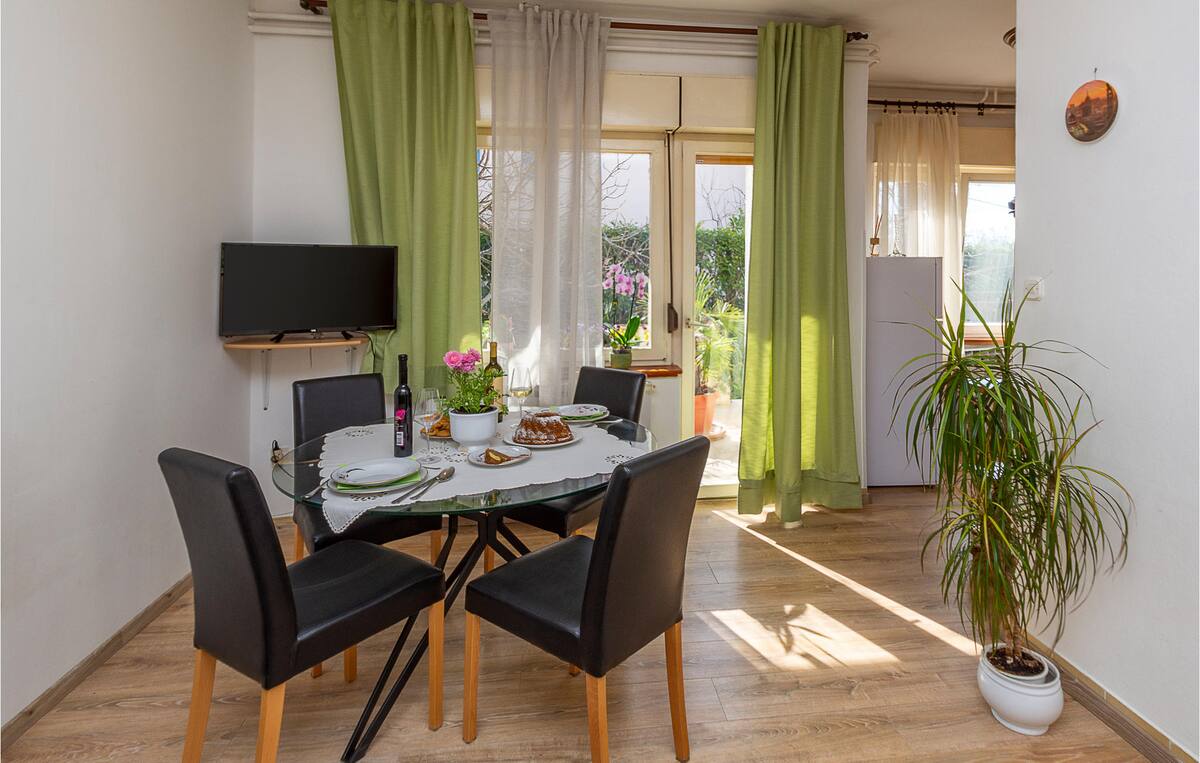 Dining room with round table, four comfortable chairs, and garden access